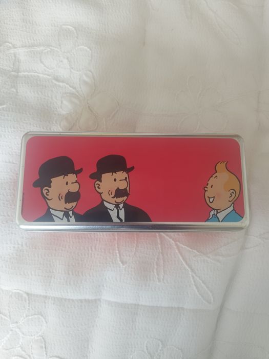 Uma caixa de metal com personagens da série de banda desenhada As Aven