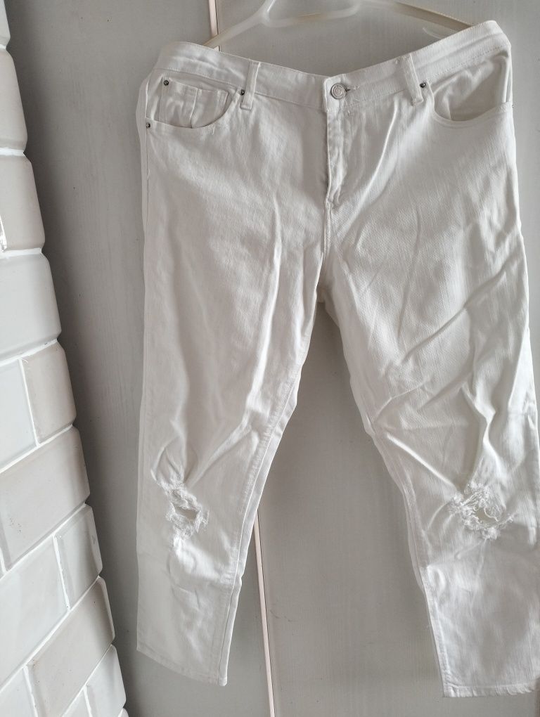 Białe spodnie jeansy rurki z dziurami damskie
