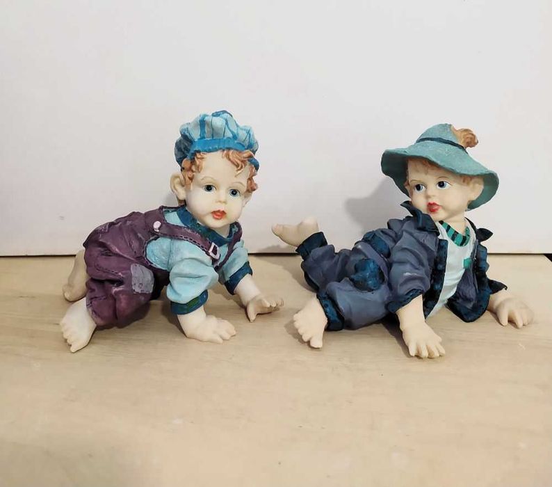 Estatuetas meninos a gatinhar