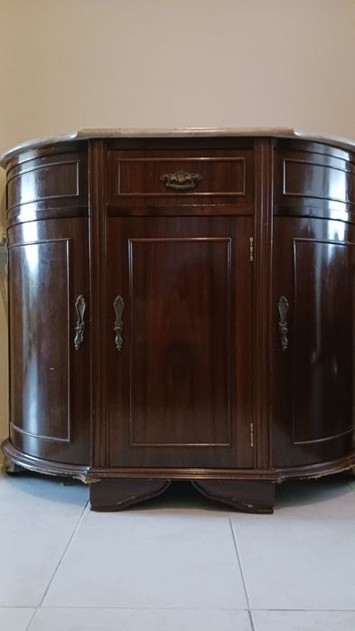 Aparador de madeira escura com tampo de mármore claro