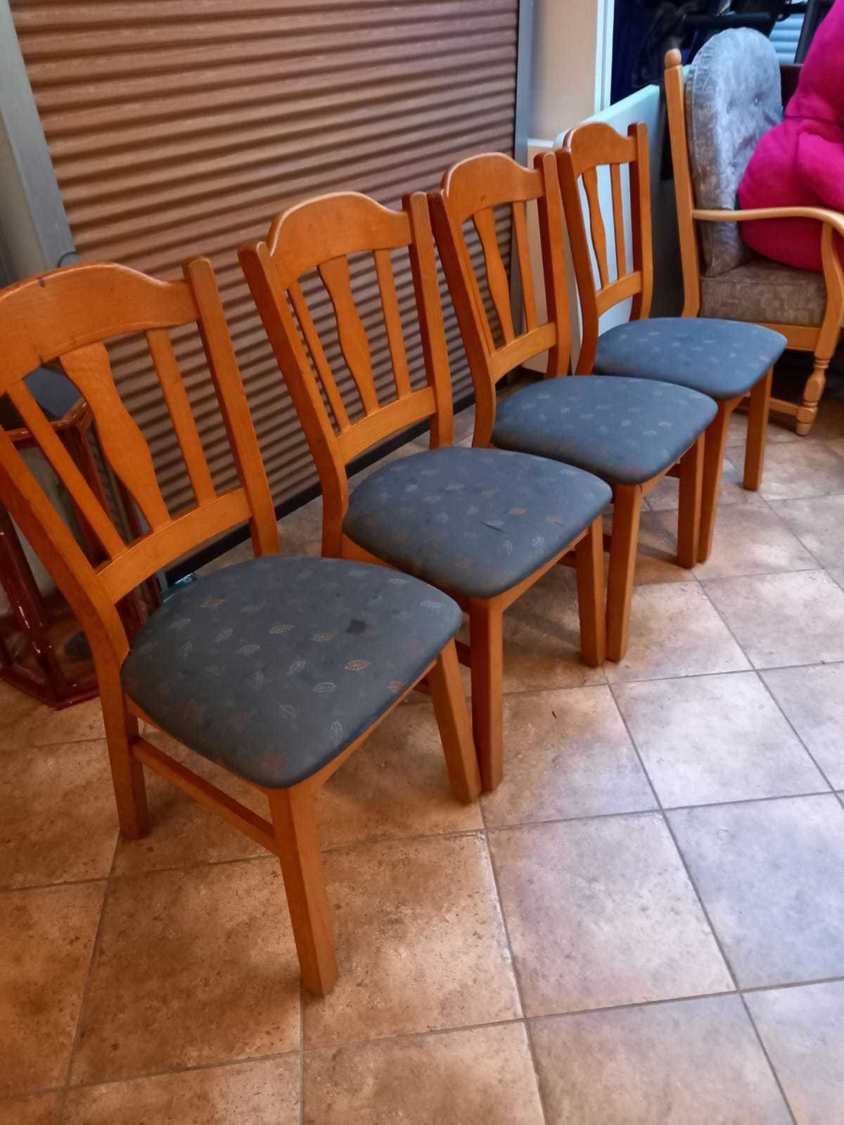 Cztery krzesła z tapicerowanym siedliskiem.