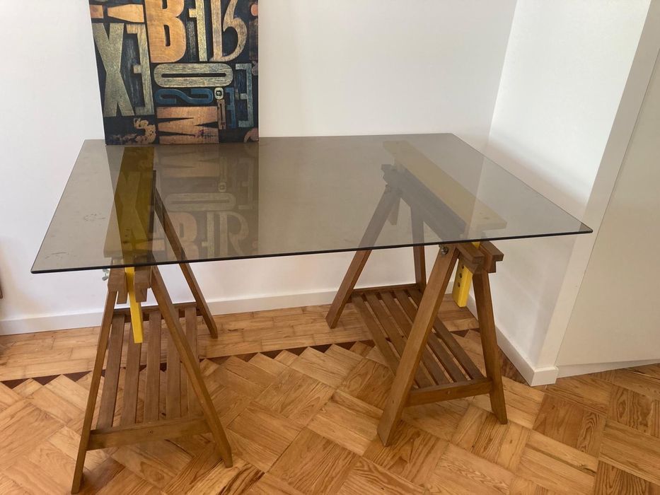 Mesa com tampo de vidro e cavaletes