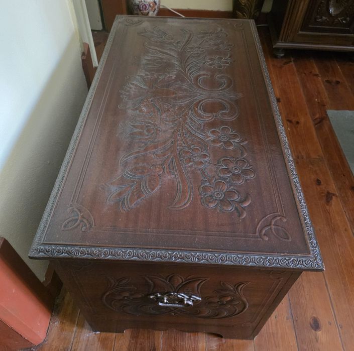 Baú em madeira com motivos em relevo.