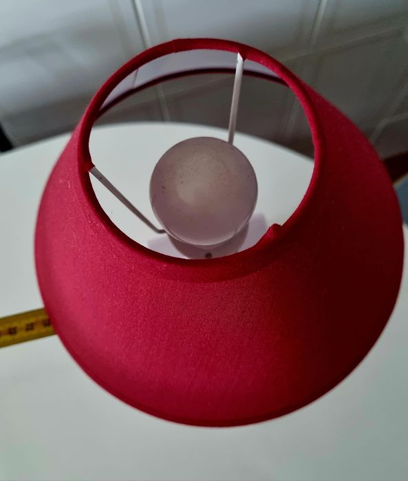 Candeeiro de mesa, feito com uma garrafa branca e abajour vermelho.