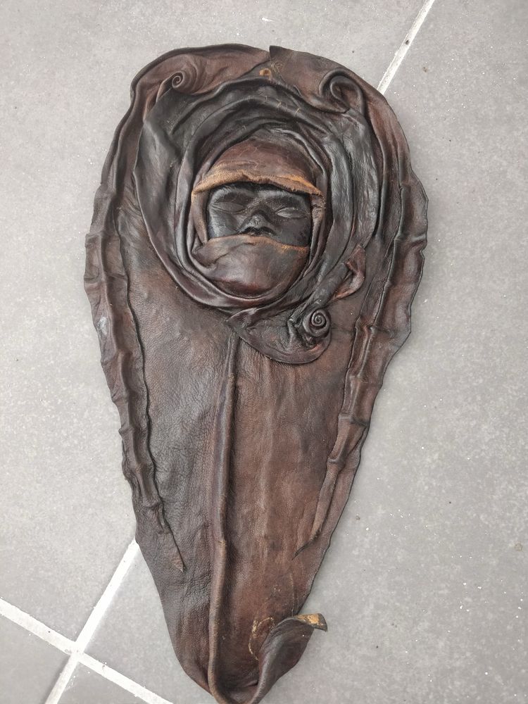 Escultura tres rostos serenos moldados em pele
