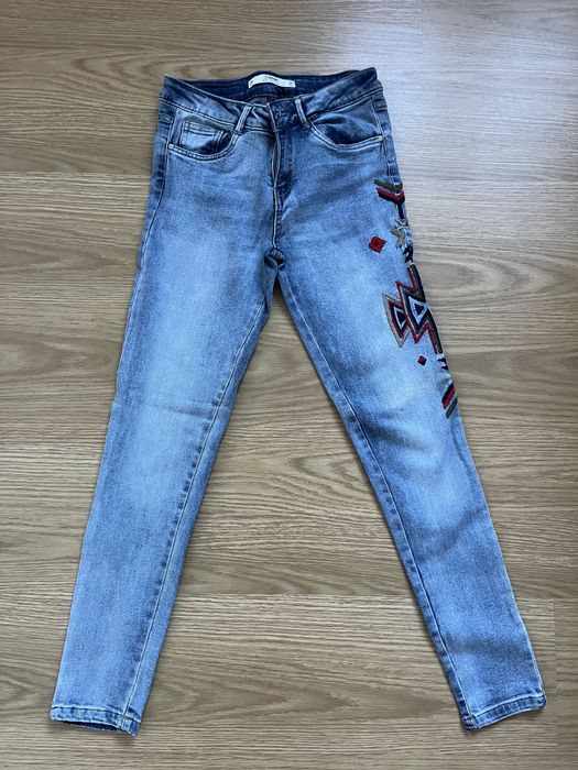 Calças de ganga azul clara com uma aplicação da Lefties