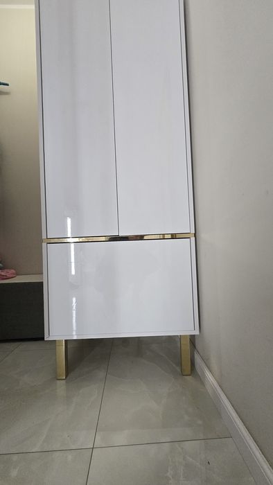 Szafa biała w połysku złote wstawki złote nóżki glamour.