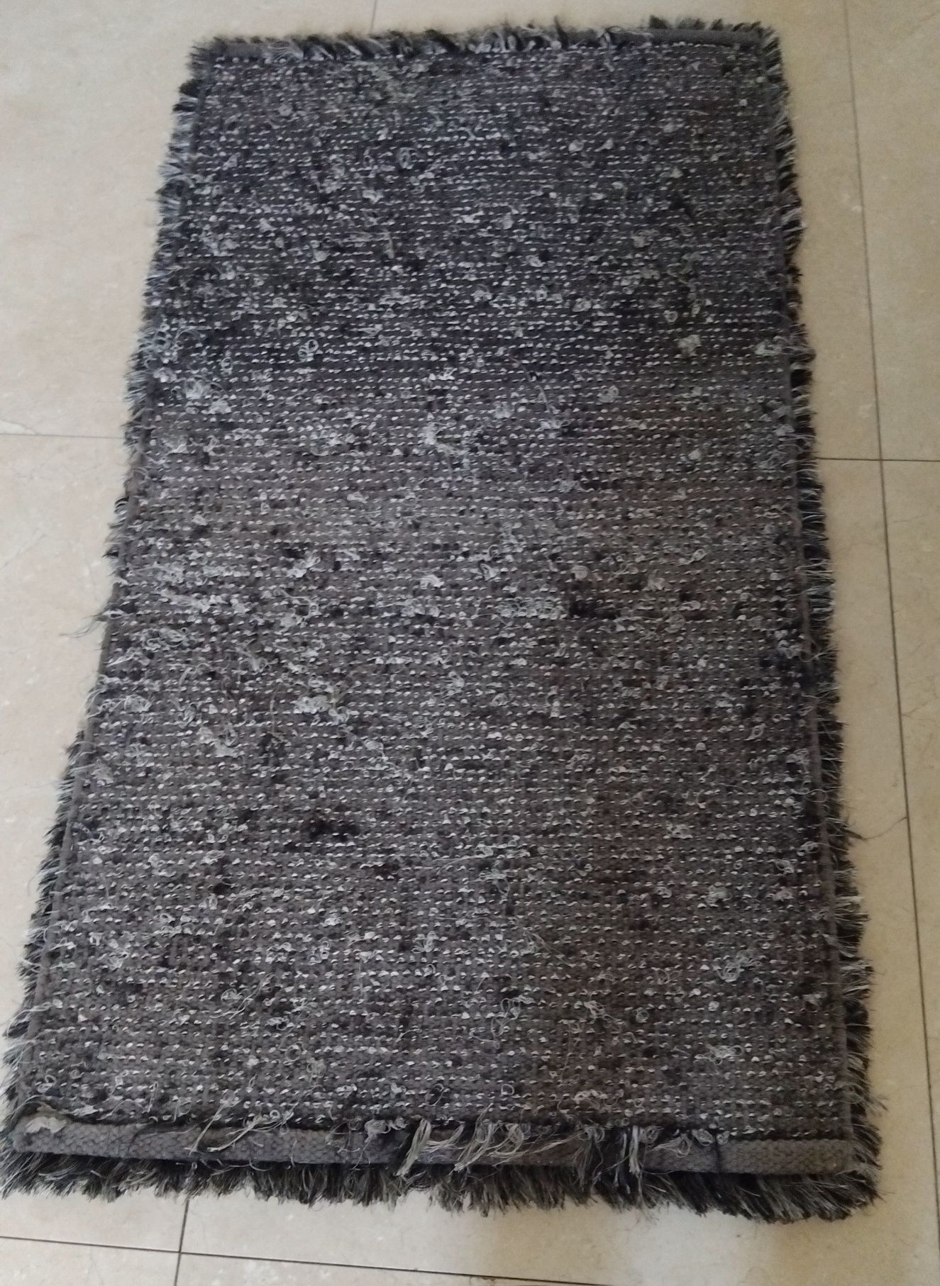 Tapete cinzento com pelos e relevo