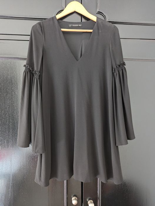 Vestido preto curto, com manga larga