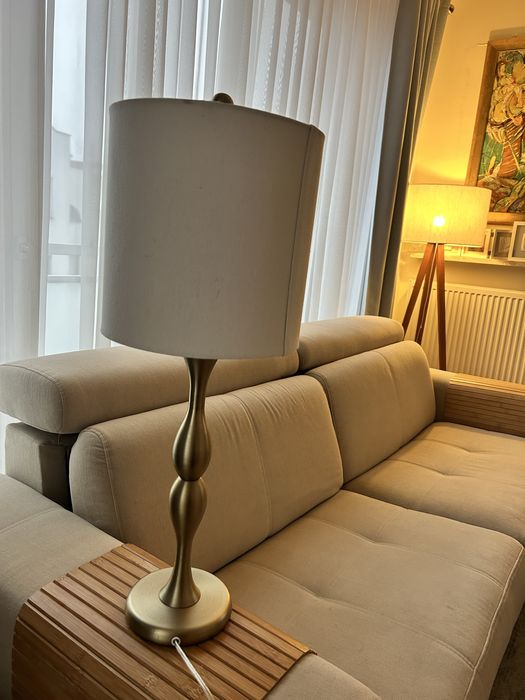 Lampa zlota z kremowym abażurem.