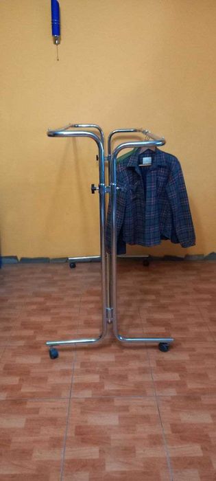 Хромована стійка-вішалка для одягу на колесах.