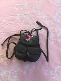 Mochila preta com flor bordada