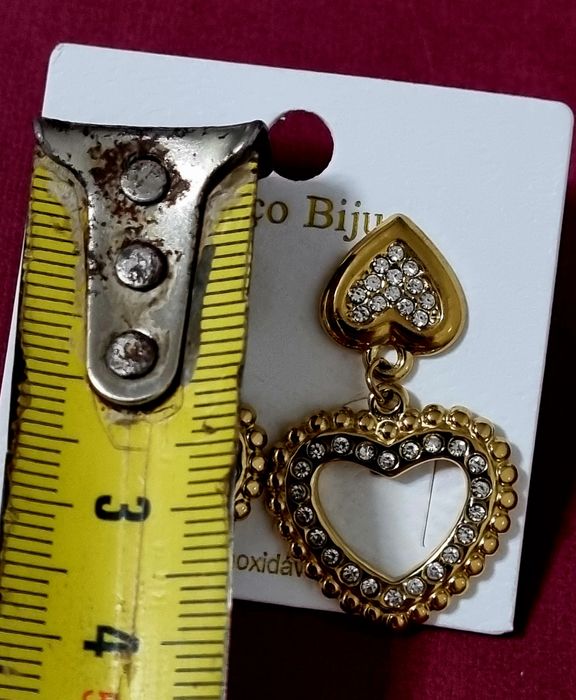 Brincos dourados, em aço, 2 corações invertidos com zirconias. De pico