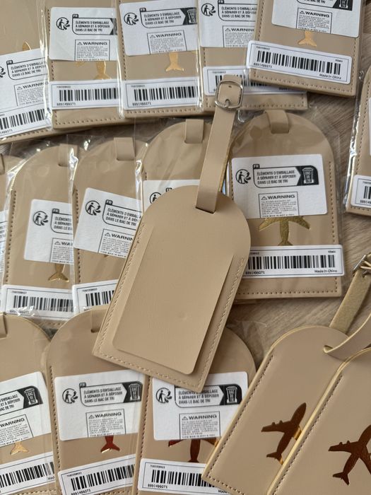 17 Beżowych zawieszek na bagaż ze złotym samolotem - prezent