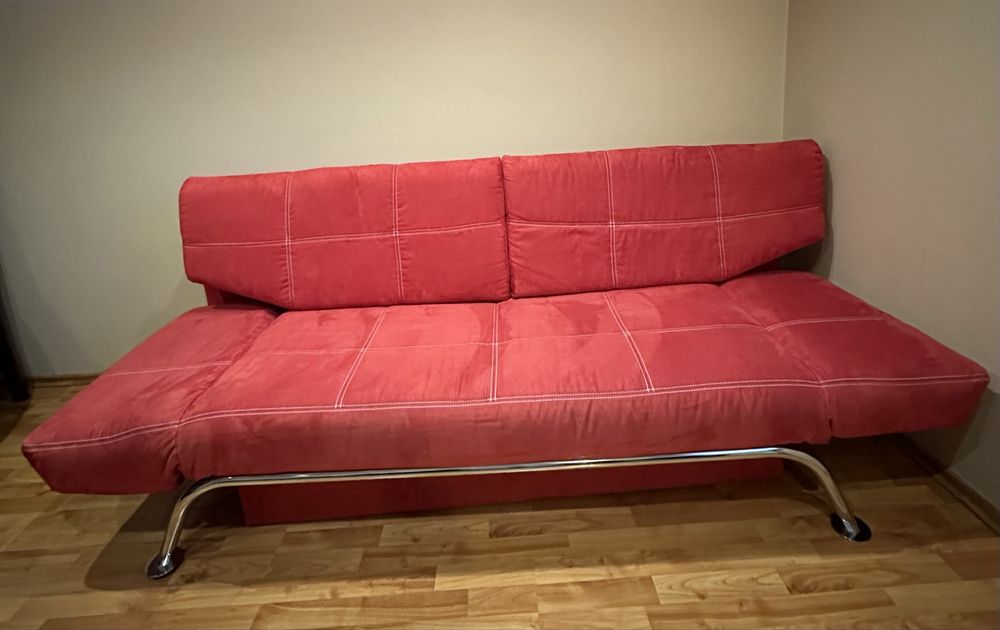 Czerwona kanapa z funkcja spania i pojemnikiem na pościel