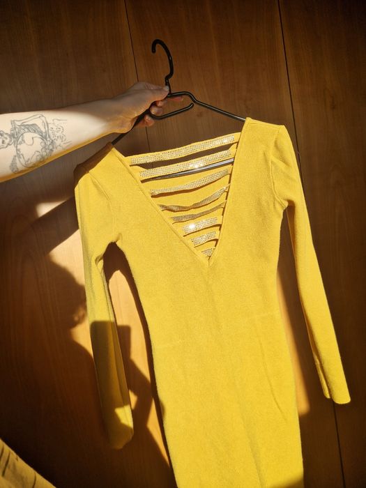 Obcisła sweterkowa sukienka z pięknie zdobionymi plecami, wycięcia