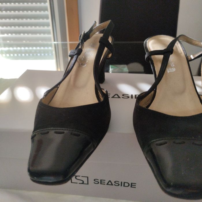 Sapatos pretos abertos atrás