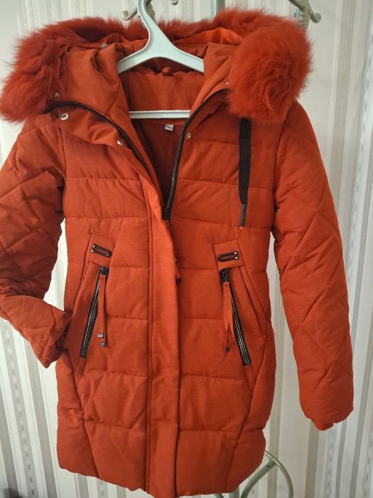 Куртка-парка червоного кольору з капюшоном, оздобленим хутром.