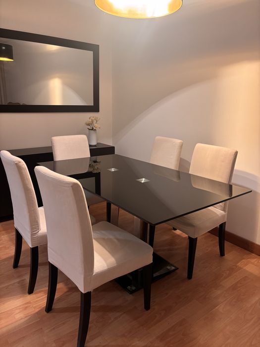 Mesa de jantar preta com cadeiras