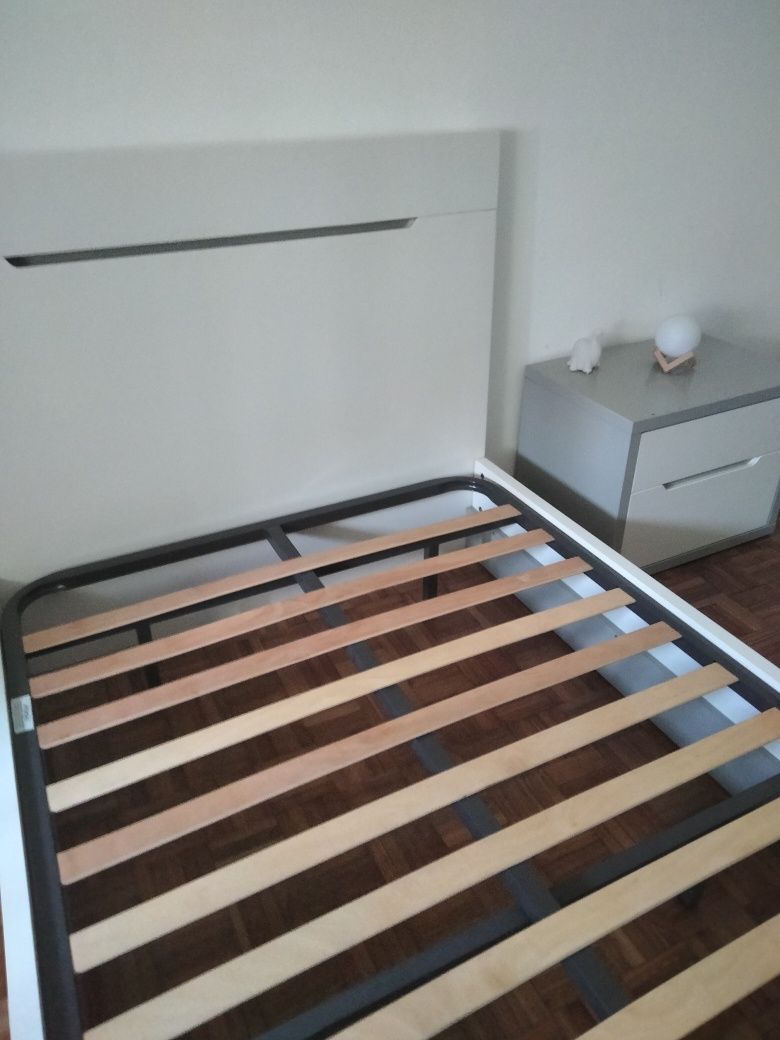Cama branca e mesa de cabeceira