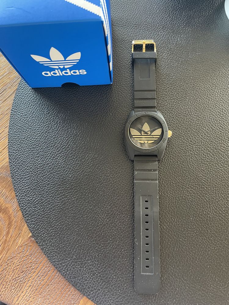 Czarny zegarek adidas na pasku, okragla tarcza, zlote dodatki