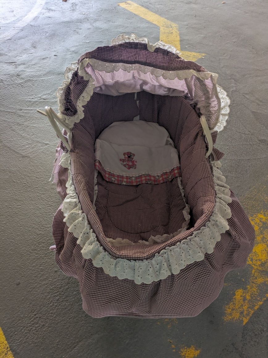 Alcofa antiga com suporte e roupa