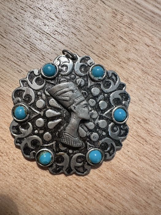 Metalowy wisior z Nefretete.