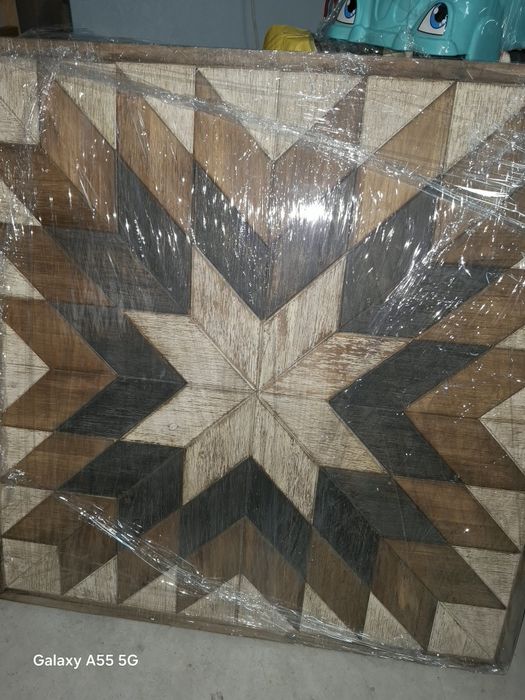 Quadro todo em madeiras de varios tons a emitar  uma rosa dos ventos