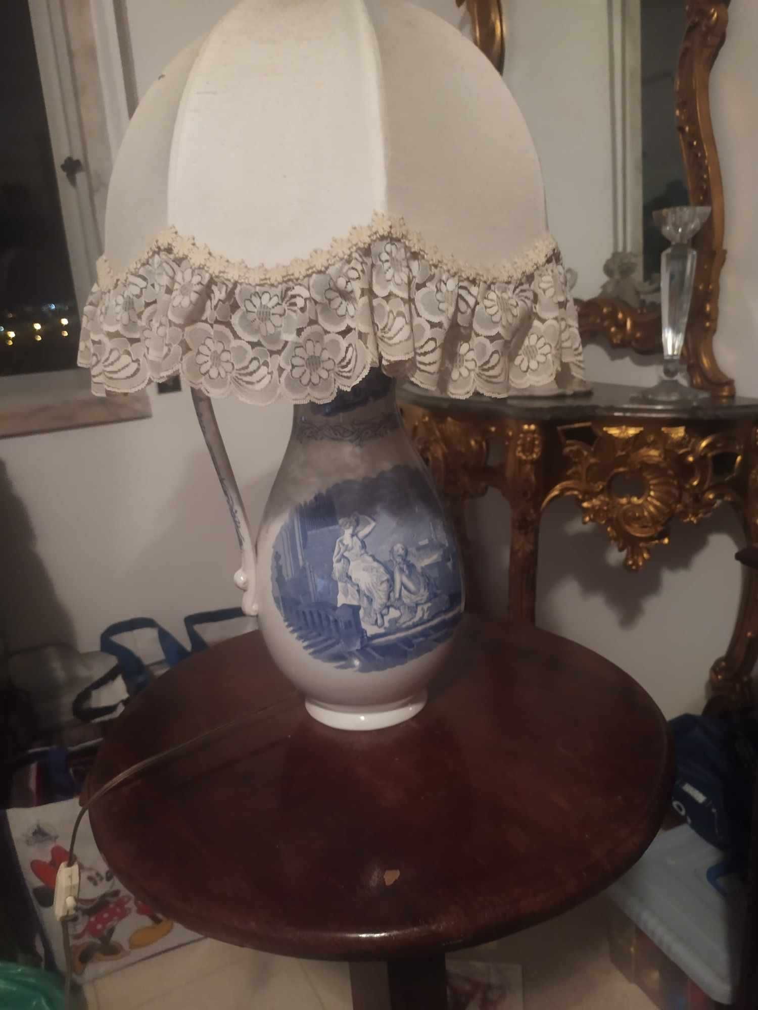 vende-se candeeiro em forma de urna  com motivo mitológico numa mesa