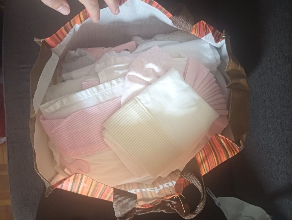 Roupa de menina e lençóis para a cama de menina