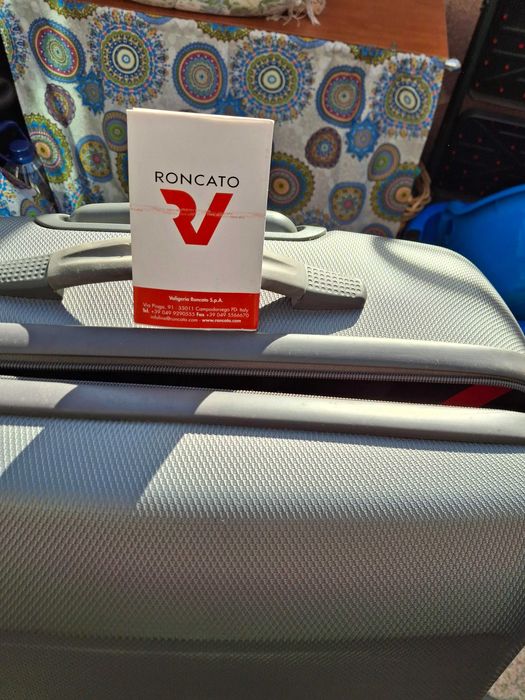 Mala de viagem cinzenta rígida com muito boa capacidade .