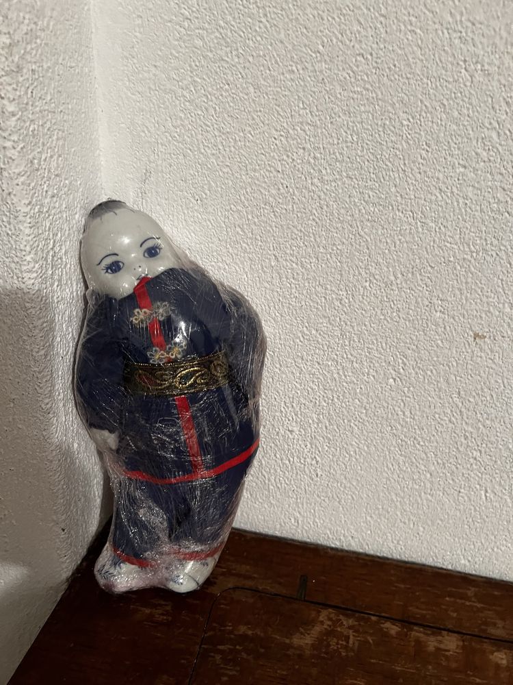 Boneco chinês com cabeça, pés e mãos em loiça