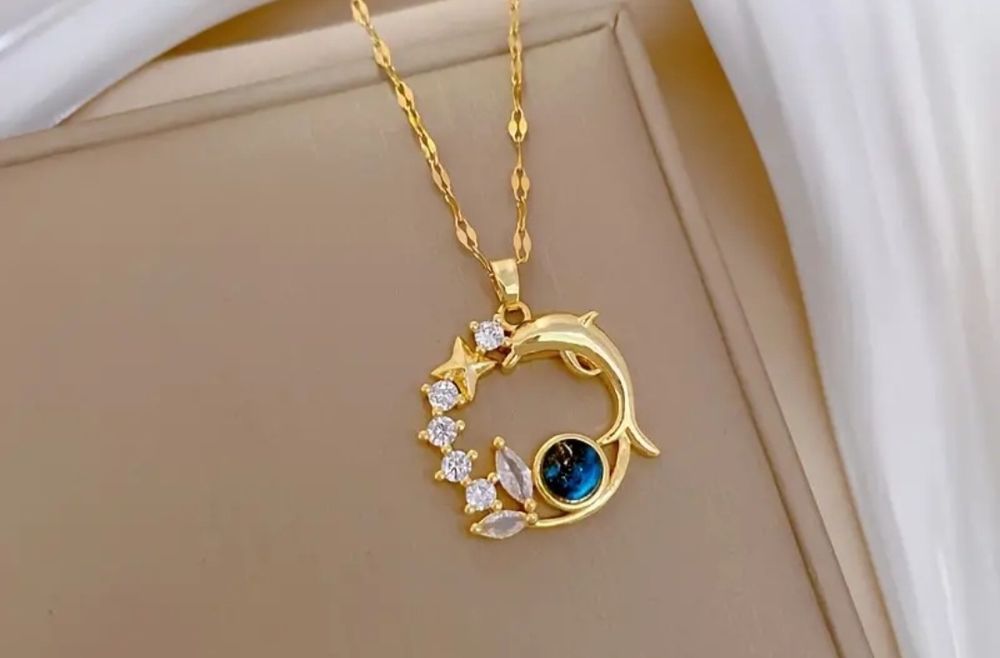 Złoty wisiorek z delfinem i gwiazdkami