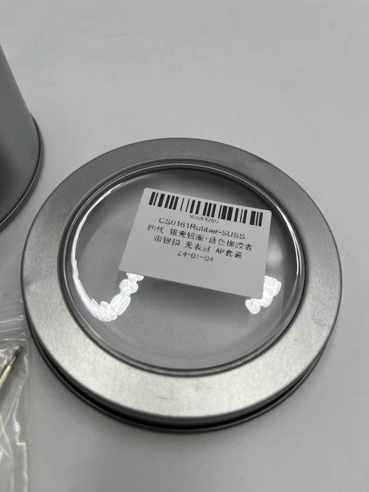 Nowa obudowa do zegarka zapakowana w metalowe pudełko.