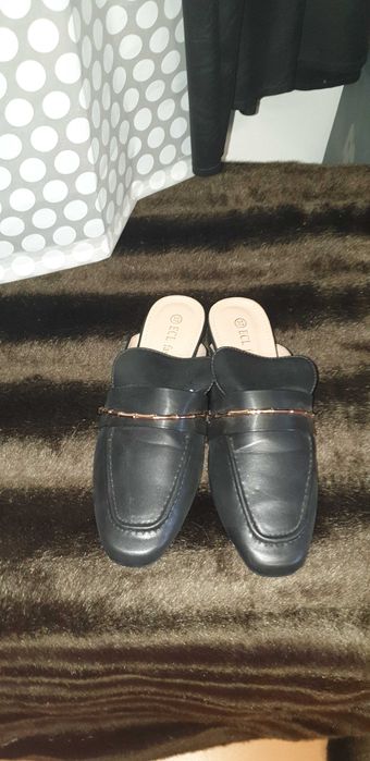 Mules pretas com detalhe dourado