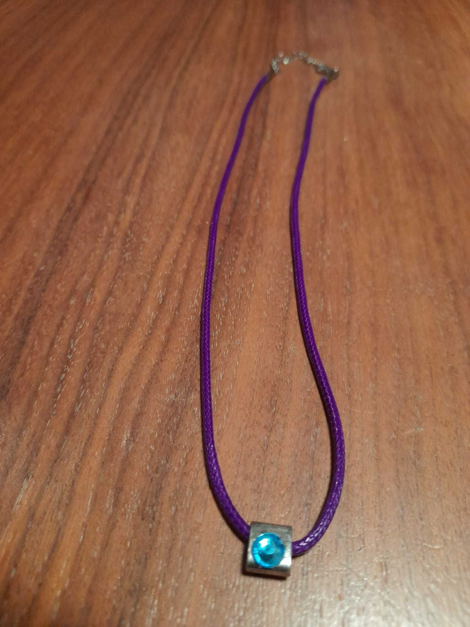 Colar rôxo com pendente prateado e "brilhante" azul. Preço: 3,50 eur