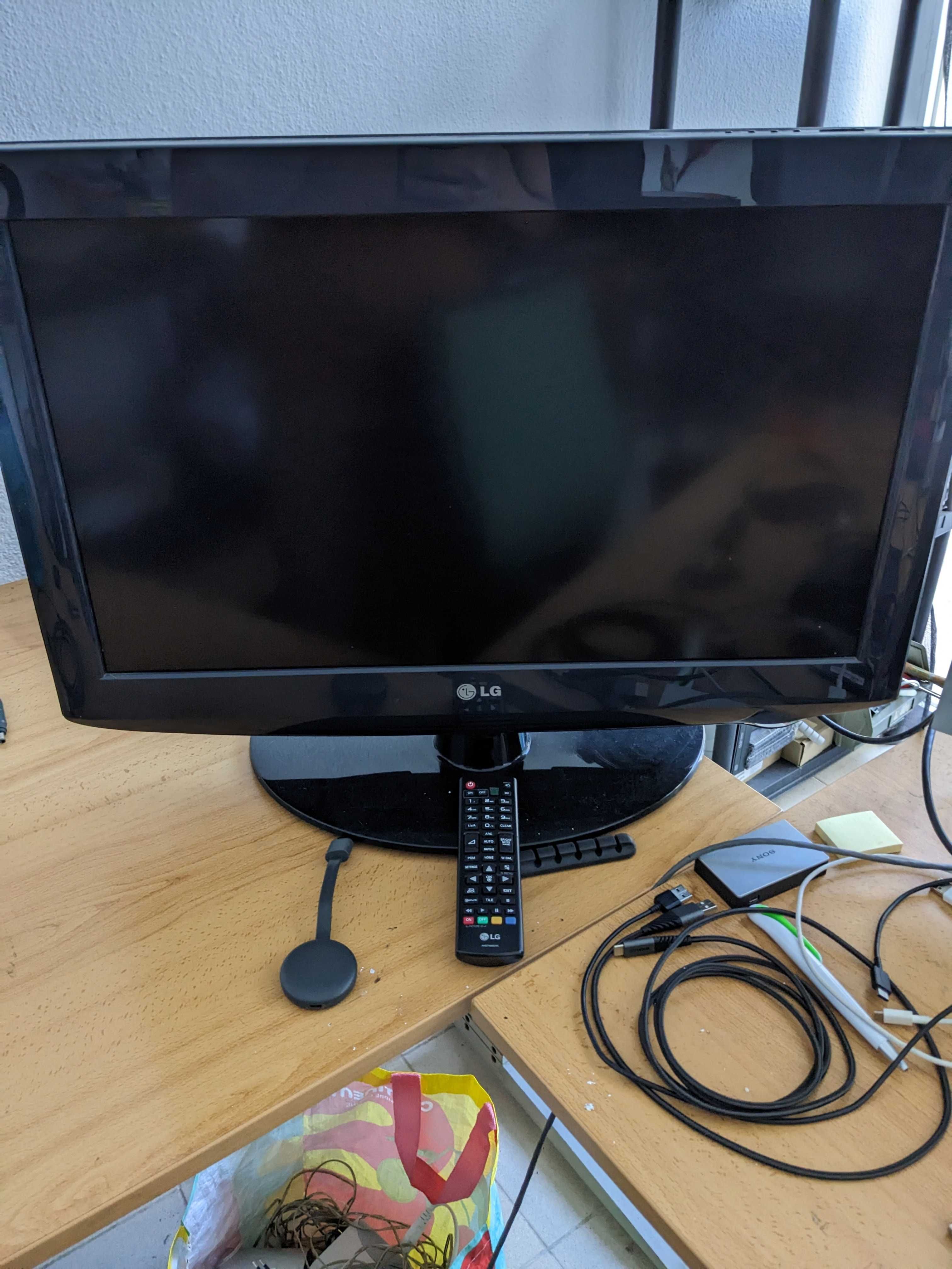 Televisão LG com comando e acessórios