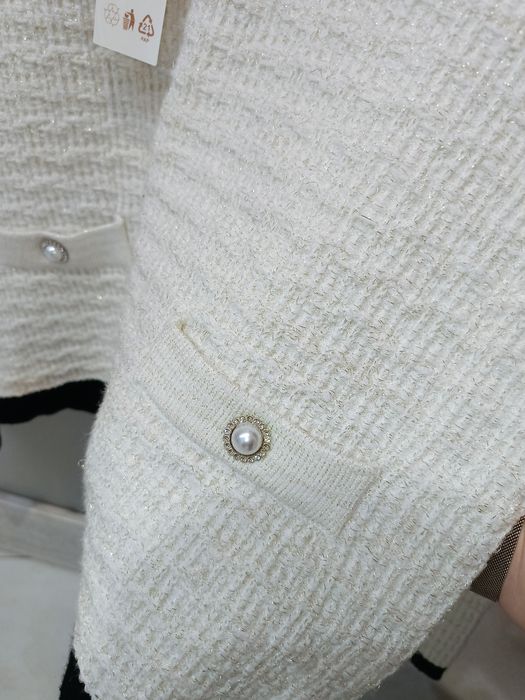 Elegancki sweterek ze zdobnymi guzikami i złotą nitką