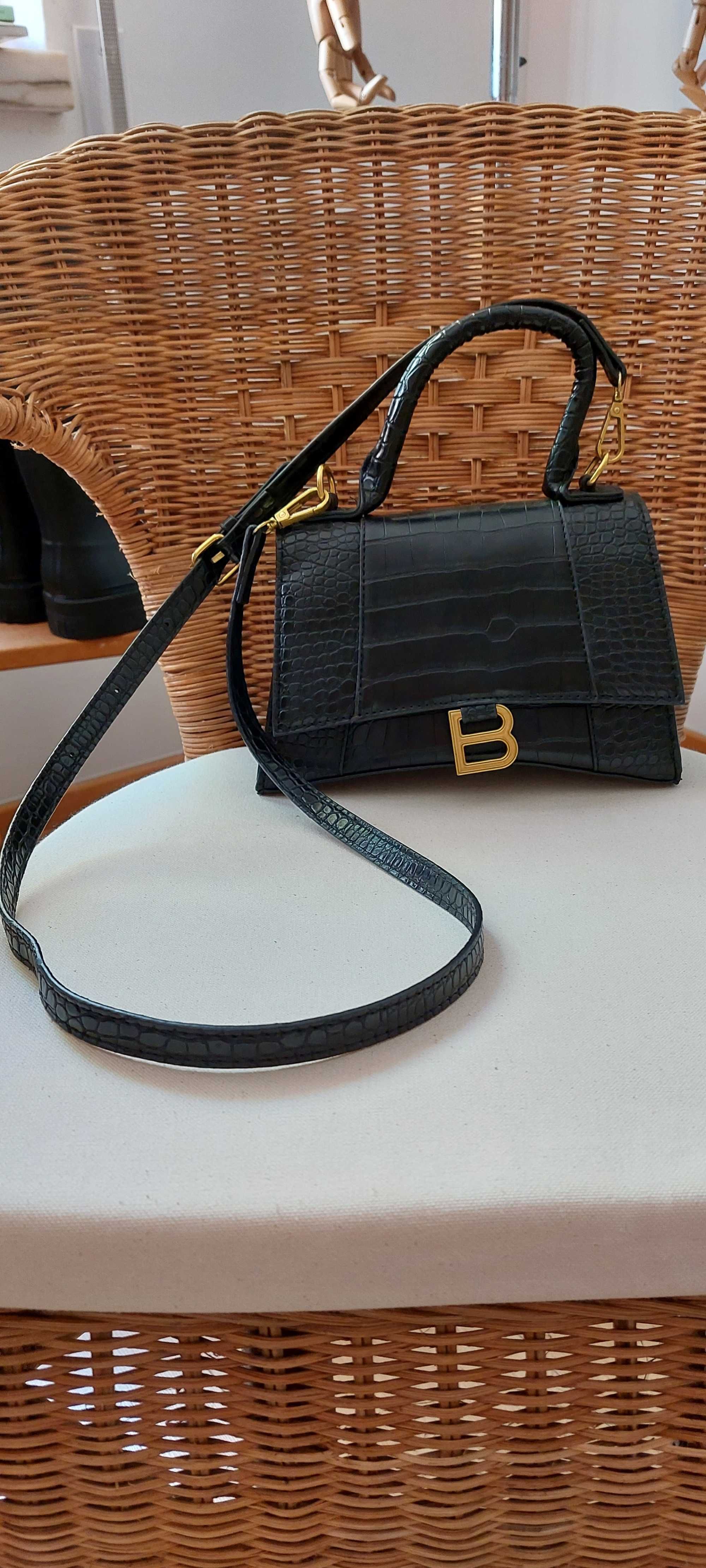 Bolsa Balenciaga preta com logo dourado.