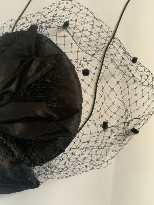 Чорний капелюшок-таблетка з вуаллю та бантом.