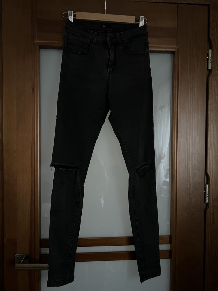 Czarne spodnie jeansowe z dziurami na kolanach