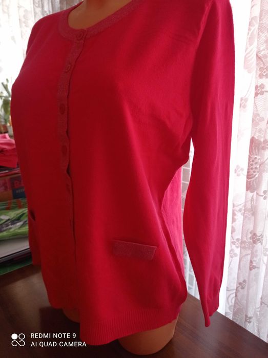 Duży ładny czerwony, damski sweterek z ozdobnym zapięciem.