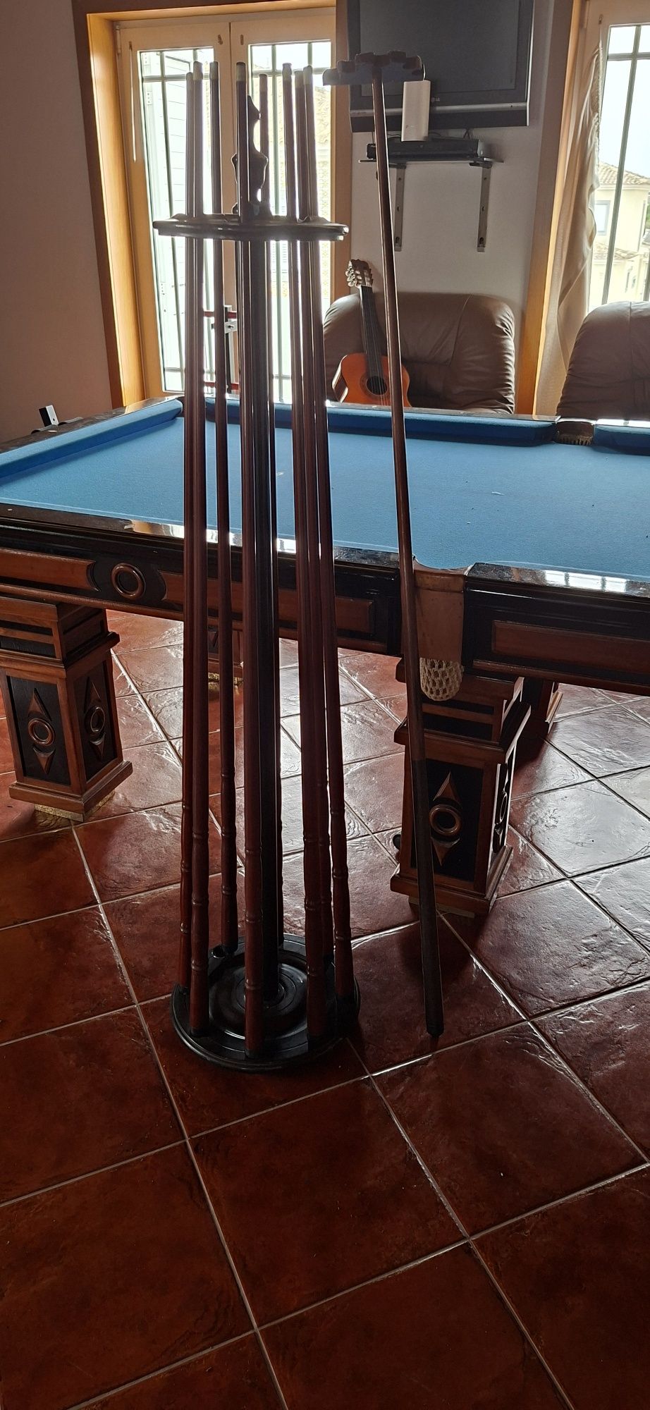 Mesa de bilhar com tacos e bolas