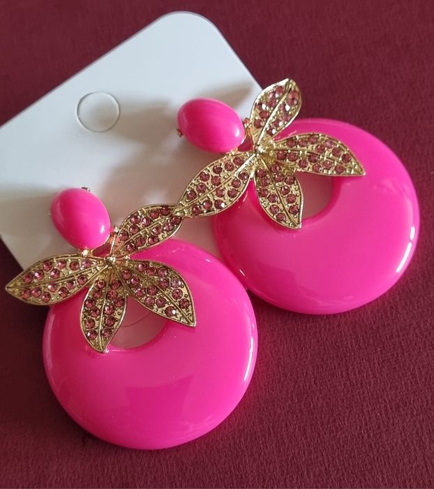 Brincos em acrílico, de pico, em rosa fucsia e apontamentos dourados.