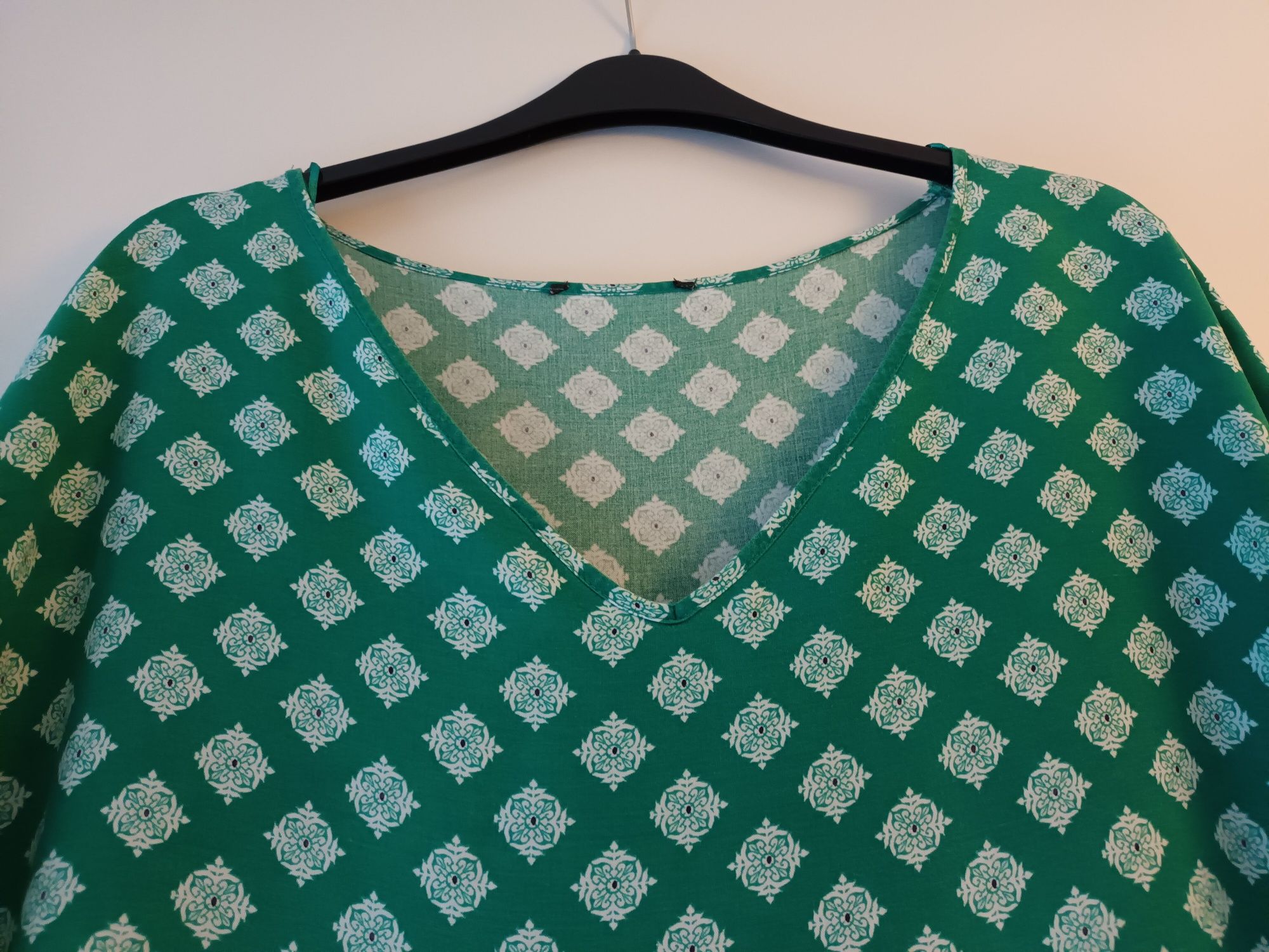 Blusa verde com padrão de flores brancas