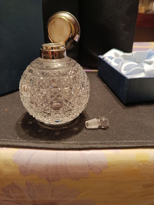 Флакон для духов с серебряной крышкой.