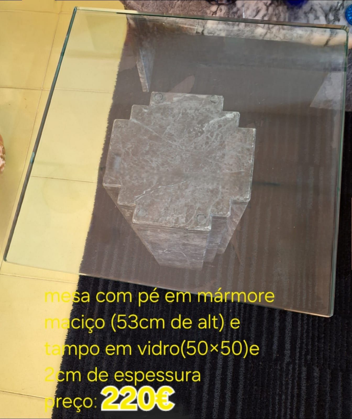 Mesa com apoio de mármore negro maciço e tampo em vidro.