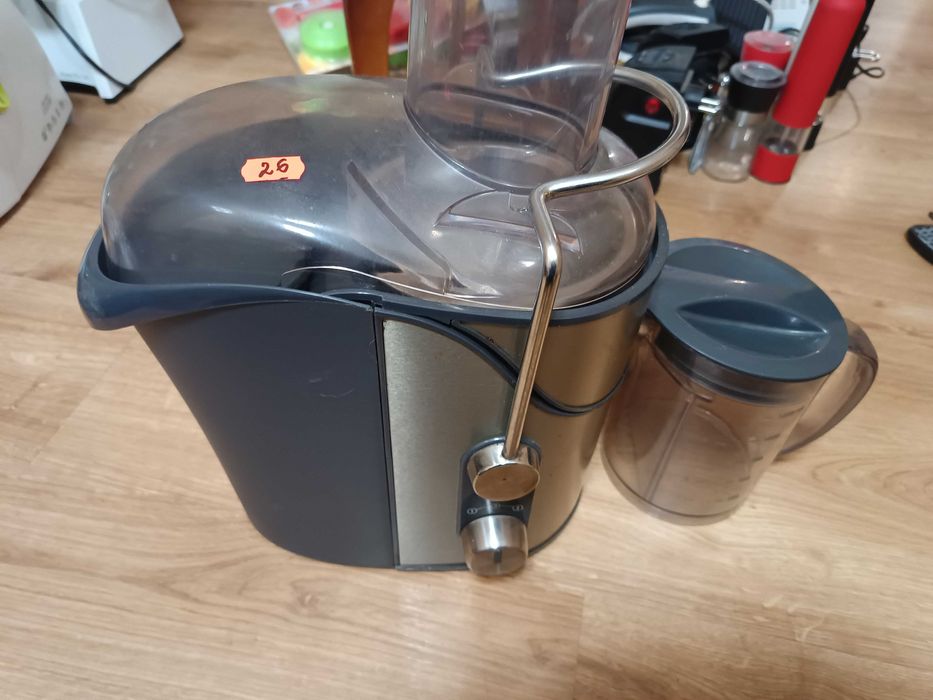 Соковыжималка серебряного цвета. Moulinex модели JU650