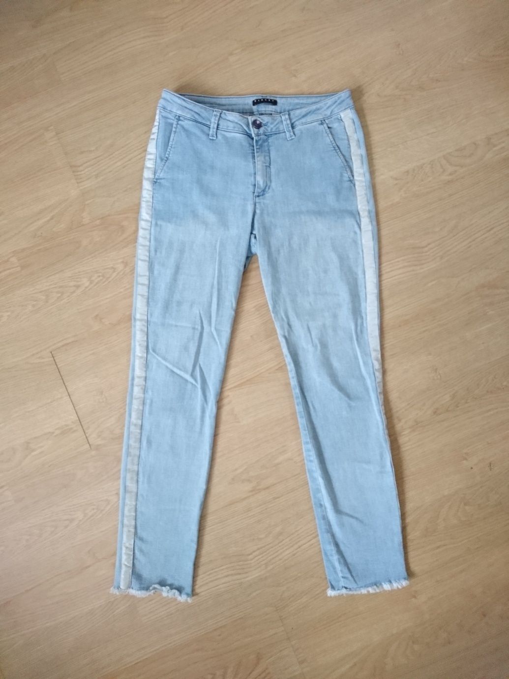 Jasnoniebieskie błękitne spodnie jeansy z białym paskiem sisley proste