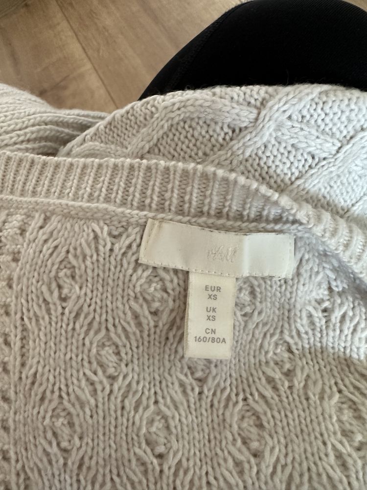 Beżowy sweter w warkoczowy splot z ozdobnymi rękawami